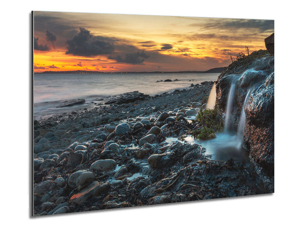 Water flows down the rocks into the sea