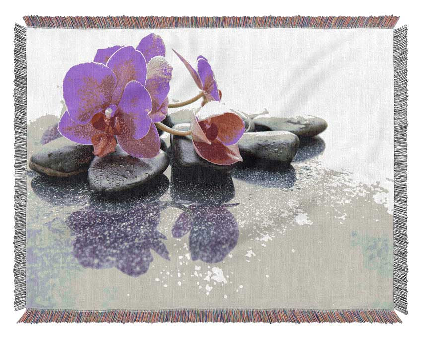 Pink orchid on the rocks Woven Blanket