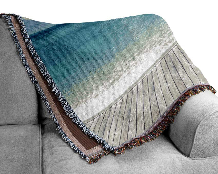 sunchairs on decking on the beach Woven Blanket