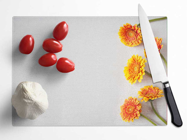 Orange Gerberas laid out Glass Chopping Board